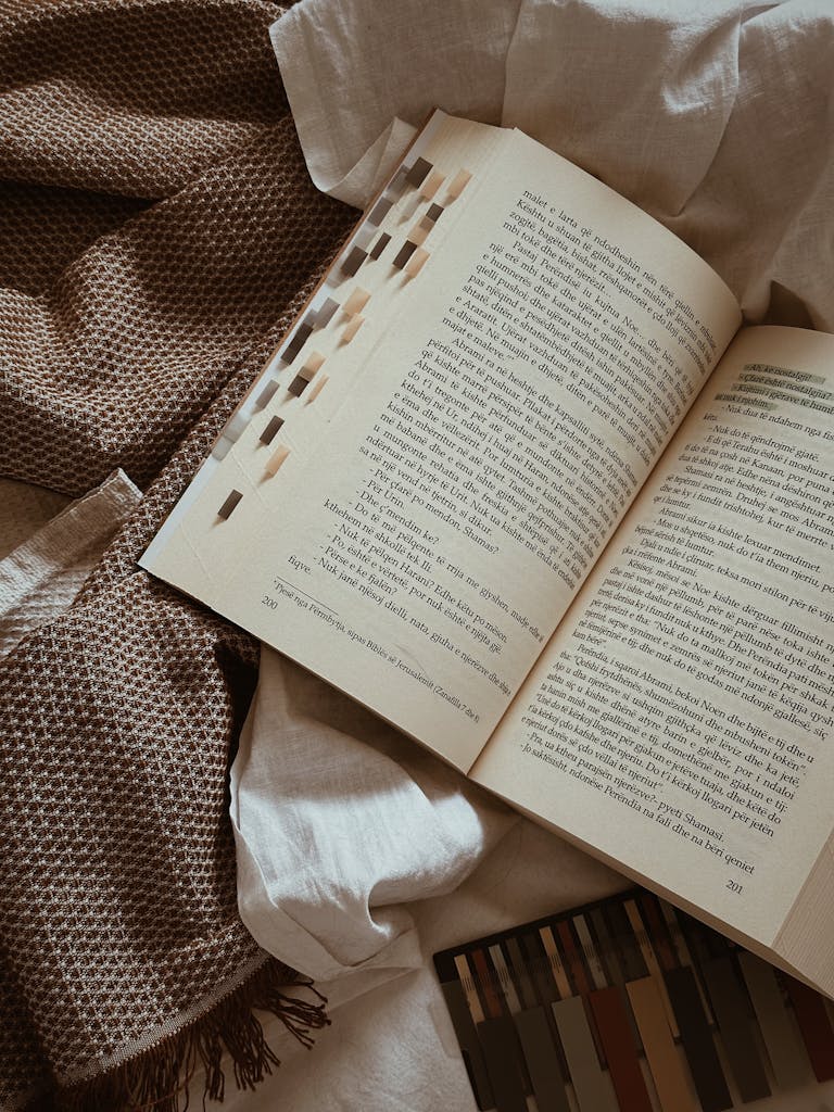 Top view of an open book on rustic fabric, ideal for literature and reading themes.