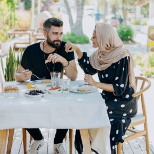 A couple sharing a meal outdoors, showcasing love and connection amidst a beautiful setting.