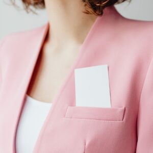 Elegant pink blazer with business card in pocket for a professional look.